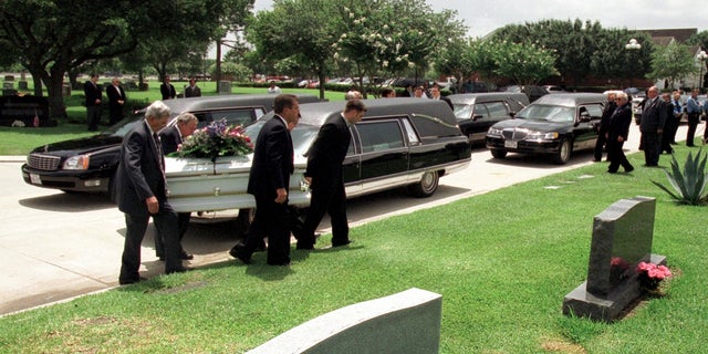 Funeral home employees carry one of the caskets of the five deceased Yates children on June 27, 2001, during their funeral at Forest Park East Cemetery in Webster, Texas.