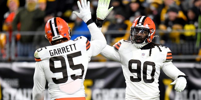 Myles Garrett, #95 of the Cleveland Browns, high fives with teammate Jadeveon Clowney, #90, in the third quarter against the Pittsburgh Steelers at Heinz Field on January 3, 2022, in Pittsburgh, Pennsylvania. 