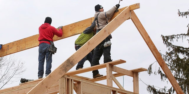 Carpenters frame a roof on a new home under construction in Nesconset, New York on February 6, 2018.
