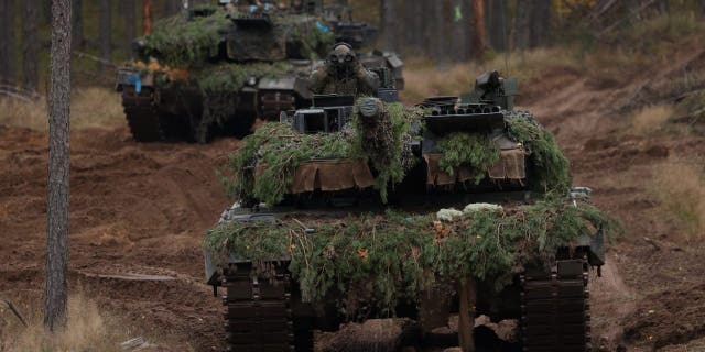 Two Leopard 2A6 main battle tanks of the Bundeswehr, the German armed forces, participate in the NATO Iron Wolf military exercises on Oct. 27, 2022, in Pabrade, Lithuania.