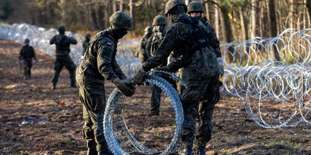 Soldiers of the Polish army installing concertina wire at Poland's border with Russian exclave Kaliningrad on Nov. 14, 2022, in Goldap, Poland.