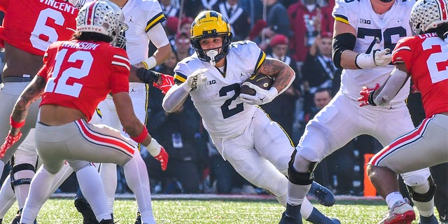 Blake Corum #2 of the Michigan Wolverines runs with the ball as Lathan Ransom #12 of the Ohio State Buckeyes prepares to tackle him during the first half of a college football game at Ohio Stadium on November 26, 2022 in Ohio Is. 
