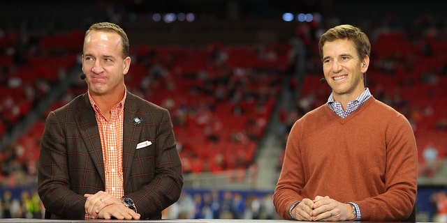 Former football quarterbacks Peyton Manning, L, and Eli Manning speak before the SEC Championship game between the LSU Tigers and the Georgia Bulldogs at Mercedes-Benz Stadium on December 3, 2022 in Atlanta, Georgia. 