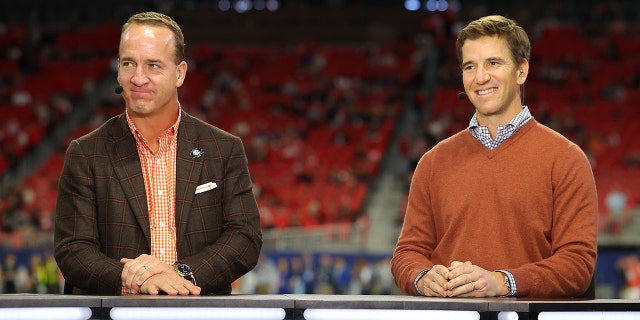 Former Football Quarterbacks Peyton Manning, L, and Eli Manning talk prior to the SEC Championship game between the LSU Tigers and the Georgia Bulldogs at Mercedes-Benz Stadium on December 03, 2022, in Atlanta, Georgia. 