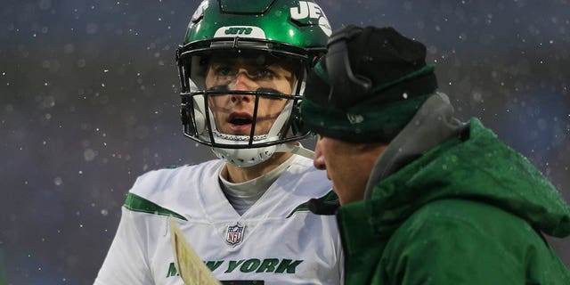 Mike White of the New York Jets speaks with offensive coordinator Mike LaFleur during the Buffalo Bills game at Highmark Stadium on December 11, 2022 in Orchard Park, New York.