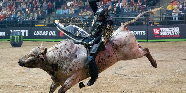 This file image shows a rider attempting to stay on a bull during the second night of the Professional Bull Riders (PBR) Minneapolis Invitational Saturday, Dec. 10, 2022 at Target Center in Minneapolis, Minn.