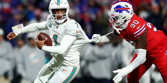 Shaq Lawson (90) of the Buffalo Bills fires Tua Tagovailoa (1) of the Miami Dolphins during the first quarter of a game at Highmark Stadium on December 17, 2022 in Orchard Park, NY 