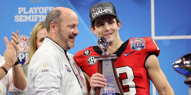Stetson Bennett of the Georgia Bulldogs is presented with the most outstanding player award after defeating the Ohio State Buckeyes in the Chick-fil-A Peach Bowl at Mercedes-Benz Stadium on Dec. 31, 2022, in Atlanta.