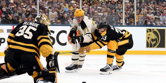Evgeni Malkin #71 de los Pittsburgh Penguins y Charlie McAvoy #73 de los Boston Bruins luchan por el disco durante el primer período del 2023 NHL Discover Winter Classic en Fenway Park el 2 de enero de 2023 en Boston, Massachusetts. 