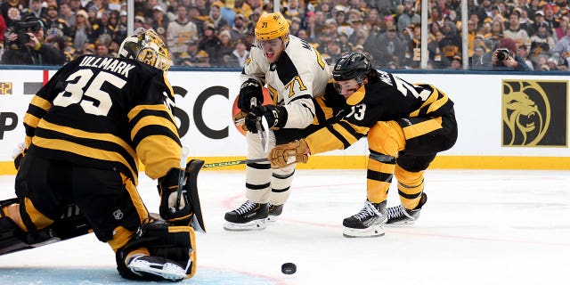 Evgeni Malkin #71 of the Pittsburgh Penguins and Charlie McAvoy #73 of the Boston Bruins compete for the puck during the first period in the 2023 Discover NHL Winter Classic at Fenway Park on January 02, 2023 in Boston, Massachusetts.