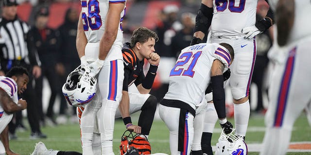 Bengals quarterback Joe Burrow and Buffalo Bills' Jordan Poyer take a knee after Damar Hamlin collapsed during the first quarter at Paycor Stadium on January 2, 2023, in Cincinnati.