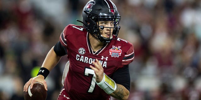 Spencer Rattler de South Carolina Gamecocks busca un pase contra Notre Dame Fighting Irish durante el TaxSlayer Gator Bowl en TIAA Bank Field el 30 de diciembre de 2022 en Jacksonville, Florida.