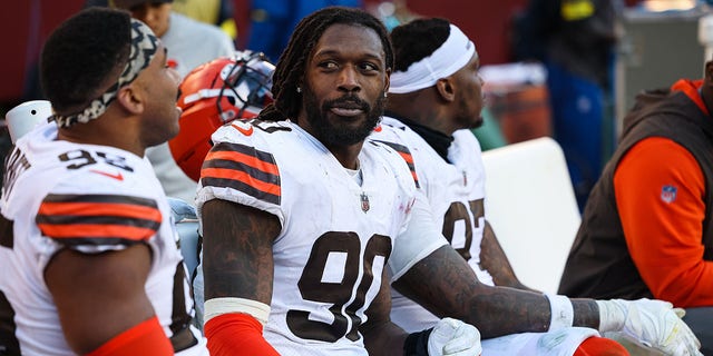Jadeveon Clowney, #90 of the Cleveland Browns, interacts with Myles Garrett, #95, on the sideline during the second half of the game against the Washington Commanders at FedExField on January 1, 2023, in Landover, Maryland. 