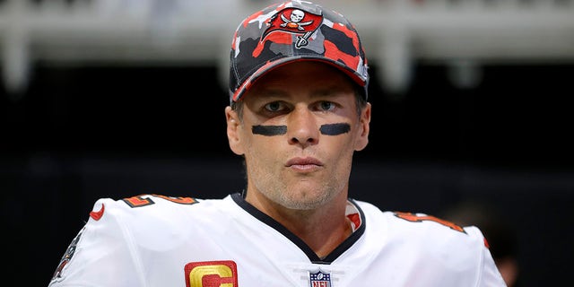 Tom Brady with eye-black on and a camo red Buccaneer's hat