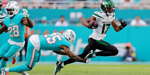 Xavien Howard (25) of the Miami Dolphins tackles Garrett Wilson (17) of the New York Jets during the third quarter at Hard Rock Stadium on January 8, 2023 in Miami Gardens, Florida. 