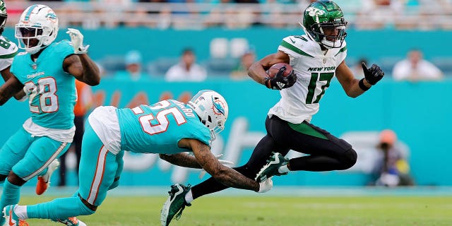 Xavien Howard (25) of the Miami Dolphins tackles Garrett Wilson (17) of the New York Jets during the third quarter at Hard Rock Stadium on January 8, 2023 in Miami Gardens, Florida. 