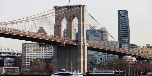 A ferry sails in the East River under the Brooklyn Bridge on January 8, 2022, in New York City.  