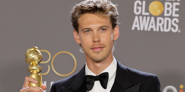 Austin Butler poses with the best actor in a motion picture – drama award for "Elvis."