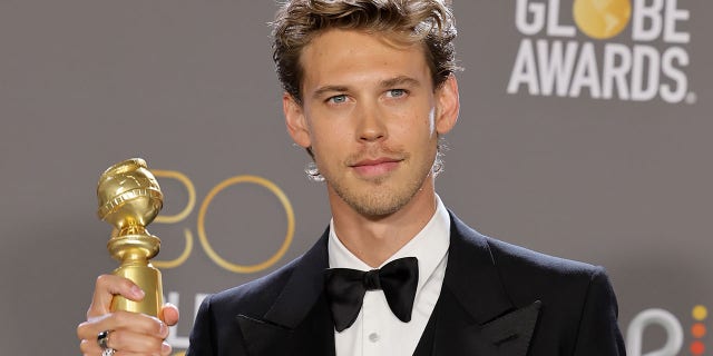 Austin Butler poses with the best actor in a motion picture – drama award for "Elvis."