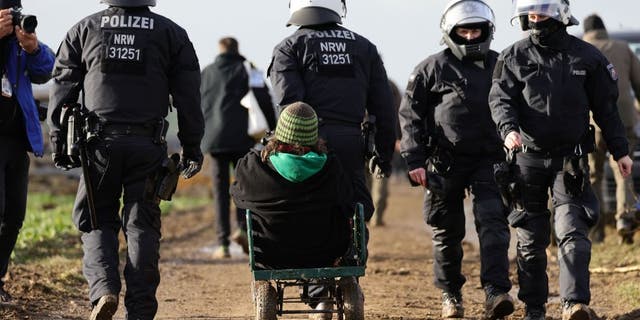 Police carry away activists at the settlement of Luetzerath, Germany, on Jan. 11, 2023.