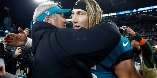 El entrenador en jefe Doug Pederson y Trevor Lawrence #16 de los Jacksonville Jaguars se abrazan en el campo después de vencer a Los Angeles Chargers 31-30 en el juego de playoffs AFC Wild Card en el TIAA Bank Field el 14 de enero de 2023 en Jacksonville, Florida. 