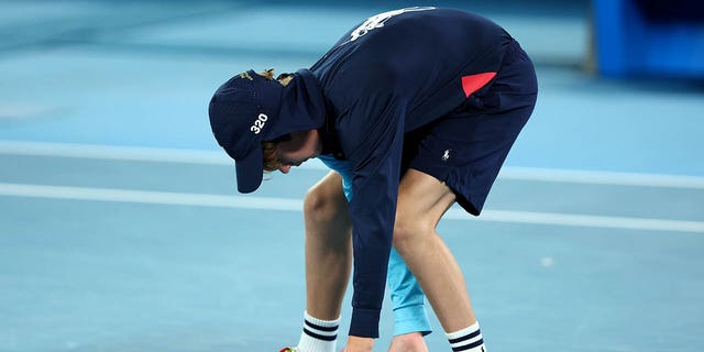A ball boy moves a moth in the quarter-final singles match between Stefanos Tsitsipas of Greece and Jiri Lehecka of the Czech Republic during day nine of the Australian Open 2023 at Melbourne Park on January 24, 2023 in Melbourne, Australia.  