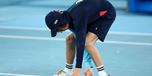 Un recogepelotas mueve una polilla durante el partido individual de cuartos de final entre Stefanos Tsitsipas de Grecia y Jiri Lehecka de la República Checa el noveno día del Abierto de Australia 2023 en Melbourne Park el 24 de enero de 2023 en Melbourne, Australia.  