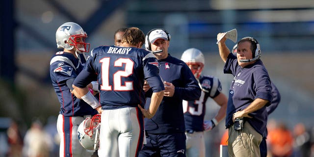 Tom Brady (12), de los New England Patriots, el entrenador en jefe Bill Belichick, extremo derecho, y el coordinador ofensivo Bill O'Brien, en el centro, conversan antes de un partido en el Gillette Stadium el 4 de octubre de 2009.
