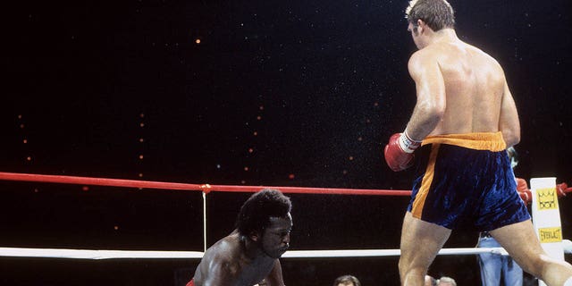Gerrie Coetzee, a la derecha, derriba a Michael Dokes durante la pelea en Richfield Coliseum en Richfield, Ohio.  Coetzee ganó el título mundial de peso pesado de la AMB por nocaut en el décimo asalto. 
