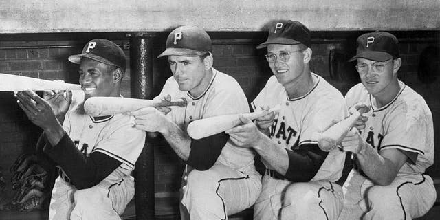 pittsburgh pirates "big guns" Roberto Clemente, Frank Thomas, Lee Walls and Bill Virdon (from left to right) all set their sights on the National League pennant in this pose on their bench.