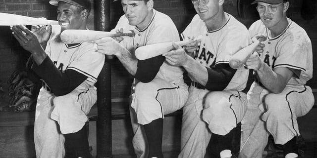 pittsburgh pirates "big guns" Roberto Clemente, Frank Thomas, Lee Walls and Bill Virdon (from left to right) all set their sights on the National League pennant in this pose on their bench.