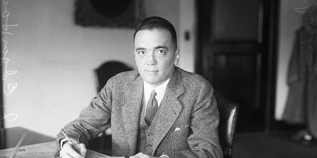 (Original Caption) 1928: Washington, D.C.: J. Edgar Hoover, director of the Federal Bureau of Investigation, sits at his desk in the Justice Department. Hoover played a key role in the Palmer Raids; he was named FBI director in 1924. 