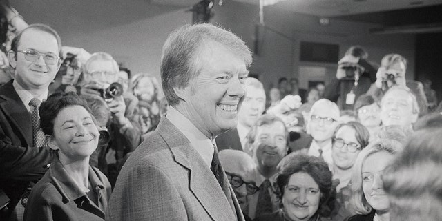 President Carter krijgt een ontmoeting met verslaggevers te zien na een persconferentie in het Executive Office Building op 9 maart 1977. Op 21 januari 1977, zijn eerste volledige dag in functie, verleende hij gratie aan dienstplichtontduikers in de Vietnamoorlog. 