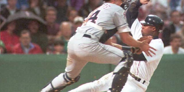 Lee Tinsley of the Boston Red Sox is safe at home on a Mo Vaughn sacrifice fly against catcher Jorge Fabregas of the California Angels in the first inning 08 June at Fenway Park.