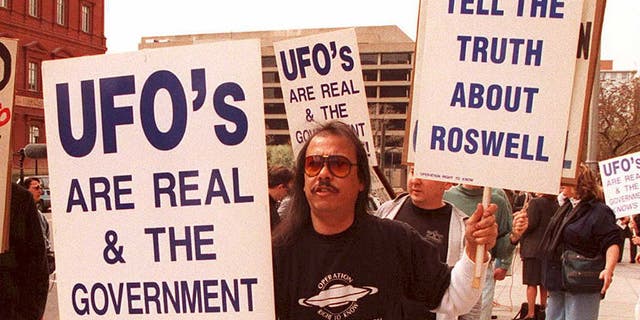 A group of protesters marches in front of the General Accounting Office March 29 to raise awareness about an examination being conducted by the GAO for documents about a weather balloon crash at Roswell, N.M., in 1947. The protesters believe the balloon was a crashed UFO.