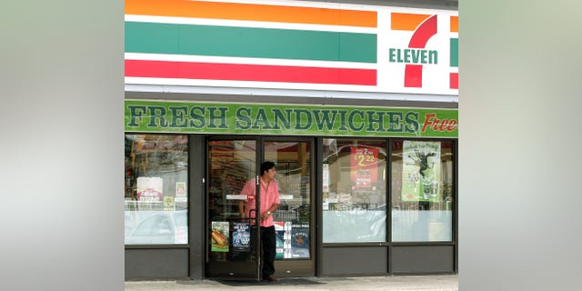 A man walks out of a 7-Eleven franchise store past a cigarette ad on a door in Texas.