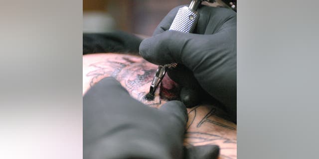 Dennis Tucker, owner of Kingtat Graphix Custom Tattoos, works on a tattoo on May 5, 2006, in Tulsa, Oklahoma. The Oklahoma Legislature gave final approval to a bill legalizing the tattoo industry in Oklahoma in 2006. It was the only state that still had a prohibition on the trade.