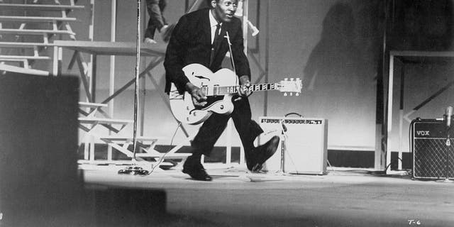 Chuck Berry performs his "duck walk" as he plays his electric hollowbody guitar at the TAMI Show on Dec. 29, 1964 at the Santa Monica Civic Auditorium in Santa Monica, California. Other performers included James Brown, The Rolling Stones, The Beatles, and Jan and Dean. 