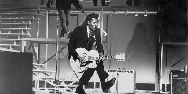 Chuck Berry performs his "duck walk" as he plays his electric hollowbody guitar at the TAMI Show on Dec. 29, 1964 at the Santa Monica Civic Auditorium in Santa Monica, California. Other performers included James Brown, The Rolling Stones, The Beatles, and Jan and Dean.