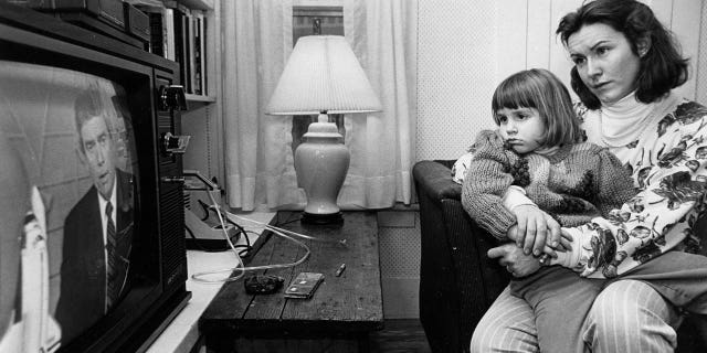 Mandana Marsh holds her daughter, Molly, 4, as they watched TV coverage hours after the explosion of the space shuttle Challenger inside their home in Concord, New Hampshire, on Jan. 28, 1986. When her mother explained what happened, young Molly asked, "Can't Christa swim?"
