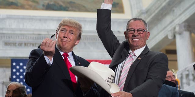 Presiden AS saat itu Donald Trump mengangkat pena setelah menandatangani topi Bruce Adams, Ketua Komisi San Juan County, setelah menandatangani Proklamasi Presiden penyusutan monumen nasional Bears Ears dan Grand Staircase-Escalante di Utah State Capitol di Salt Lake City , Utah, 4 Desember 2017. (SAUL LOEB/AFP via Getty Images)