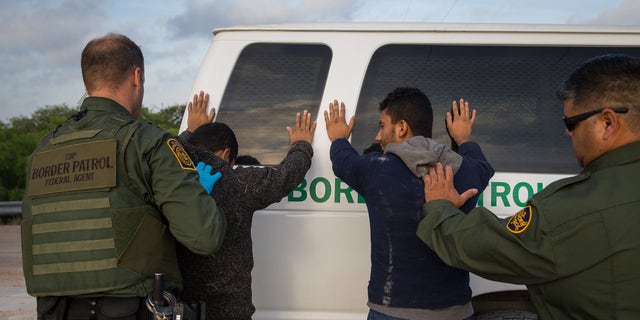 Agen Patroli Perbatasan menangkap imigran ilegal tak lama setelah mereka melintasi perbatasan dari Meksiko ke Amerika Serikat, 26 Maret 2018, di Sektor Lembah Rio Grande dekat McAllen, Texas.  (Loren Elliott / AFP melalui Getty Images)