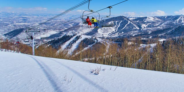 Skiers are sitting in a chair lift with panoramic view of the Wasatch Range in the Rocky Mountains on March 02, 2015 in Park City, Utah, United States. 