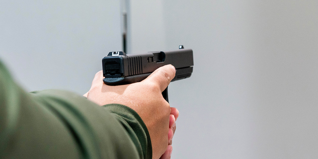 Seorang pelanggan memegang pistol Glock 17 untuk dijual di Redstone Firearms, di Burbank, California, AS, pada Jumat, 16 September 2022. 