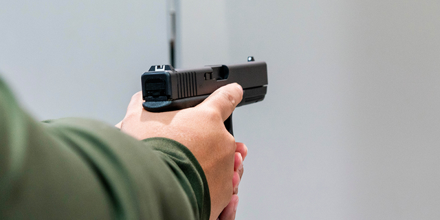 A customer holds a Glock 17 pistol for sale at Redstone Firearms, in Burbank, California, US, on Friday, Sept. 16, 2022. 