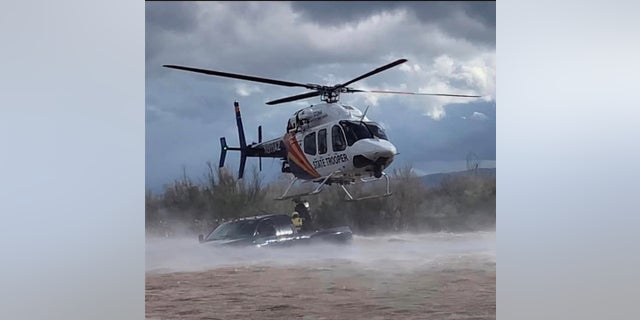 A helicopter crew rescues a driver from a flooded creek in Arizona.