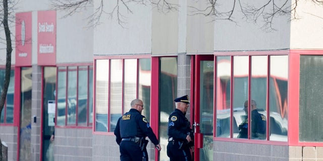 Law enforcement officers enter the Starts Right Here building on Monday in Des Moines, Iowa. Police say two students were killed and a teacher was injured in a shooting at the Des Moines school on the edge of the city's downtown. 