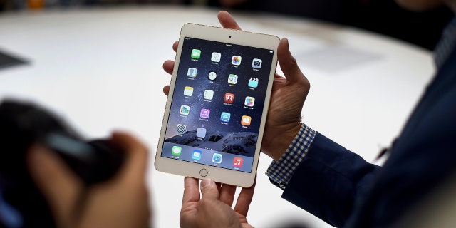 Seorang anggota media memajang iPad Mini 3 Apple Inc. untuk difoto setelah pengumuman produk di Cupertino, California, AS, Kamis, 16 Oktober 2014.