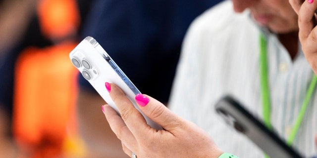 Seorang peserta memegang iPhone Pro baru selama acara peluncuran produk baru di Apple Park di Cupertino, California, pada 7 September 2022.