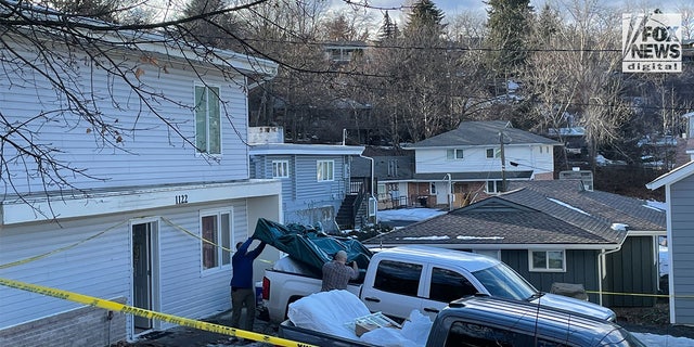 People carry items, including a mattress with potential blood stains, from the home where four University of Idaho students were killed.